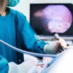 Surgeon using tool to examine pet.
